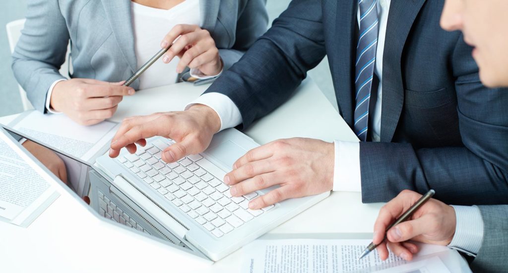 three business people working on a laptop