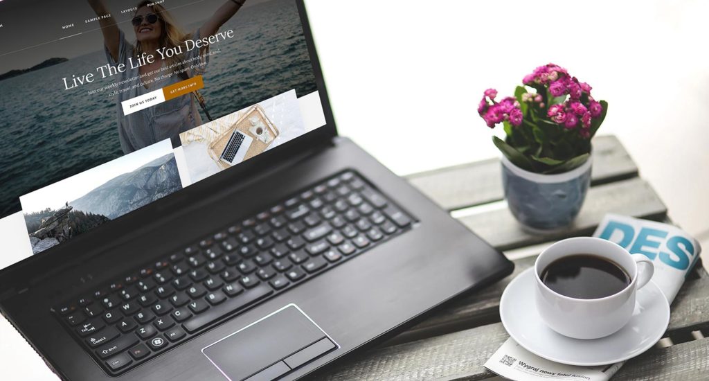 laptop screen with the Essence Pro theme on the screen while a flower and cup of coffee sit nearby
