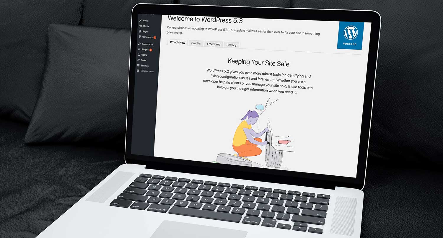 WordPress 5.2 welcome screen on a laptop sitting on a black couch