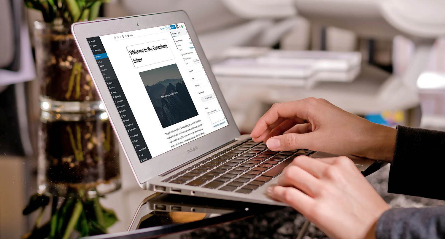 Someone using the Gutenberg editor on a laptop on a clear table