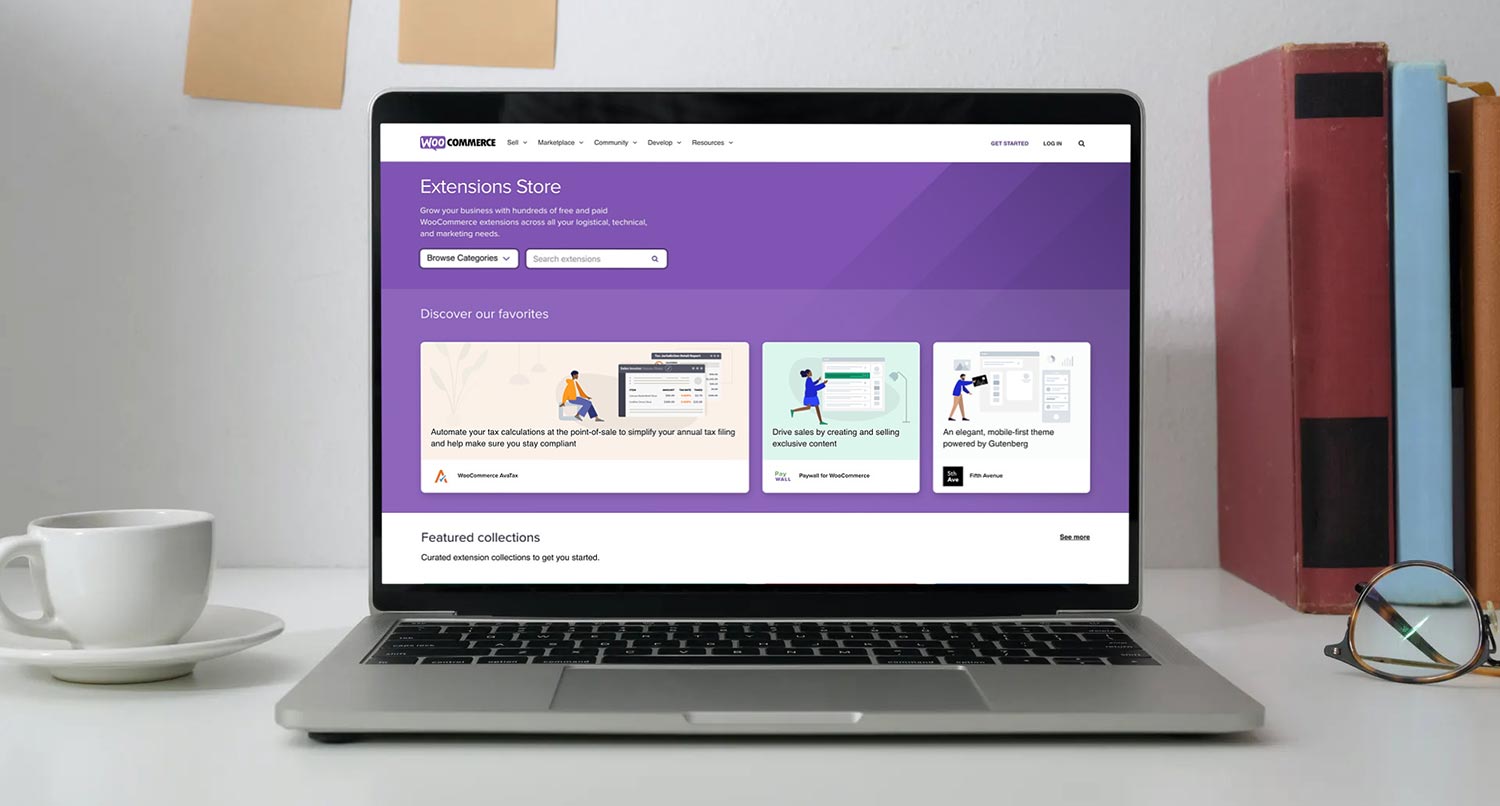 A laptop on a white desk showing the WooCommerce extensions landing page