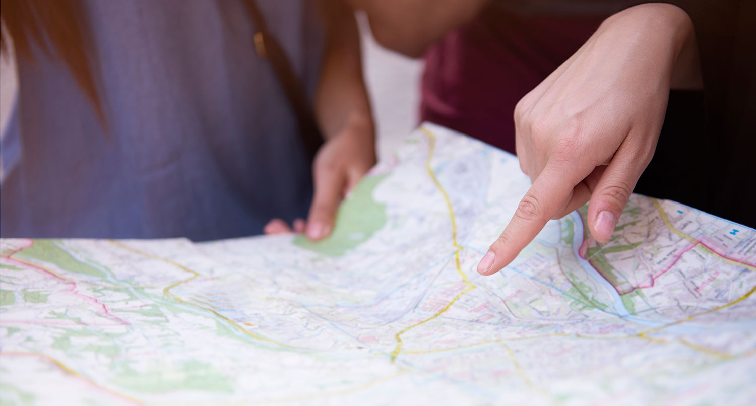 three people looking at a physical map of a city