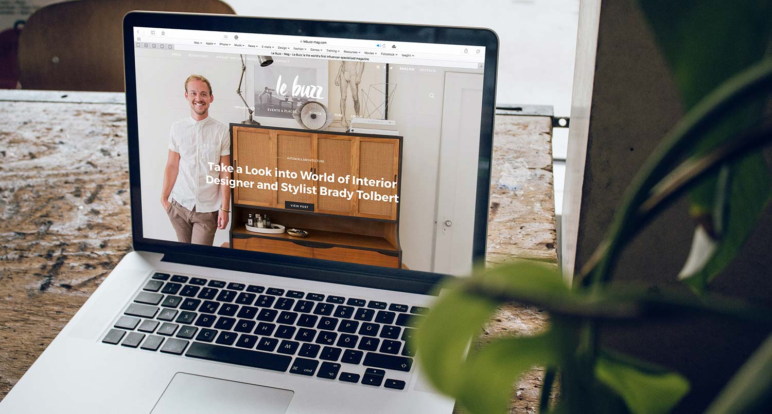 A laptop showing the website for a business sitting on a wood desk
