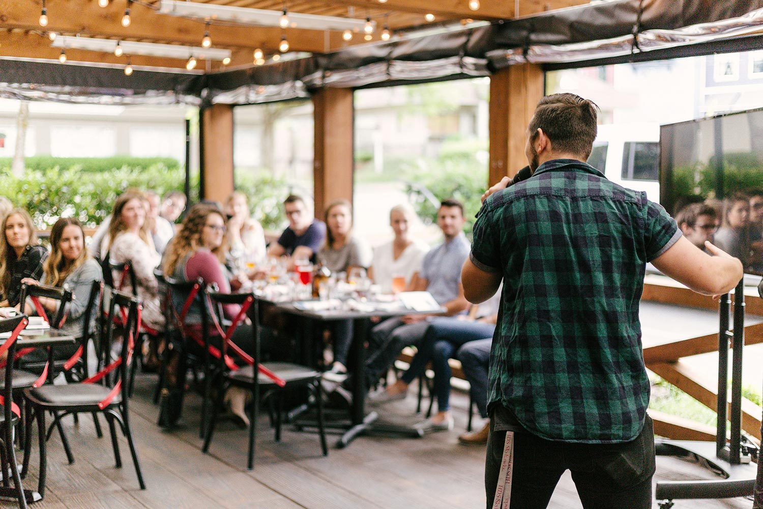 a man speaking at an event on a patio