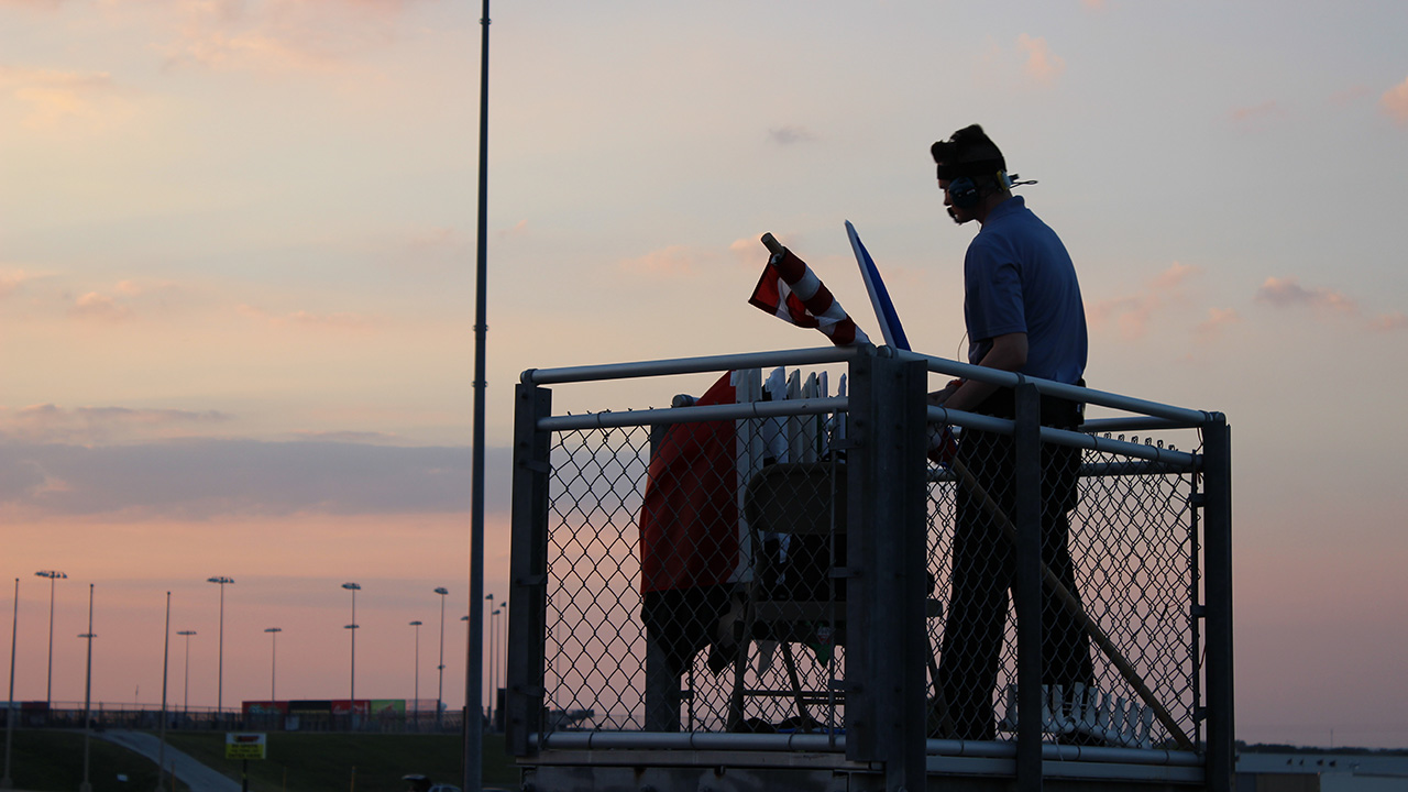 A flag man watches a race from his stand at Texas Motor Speedway