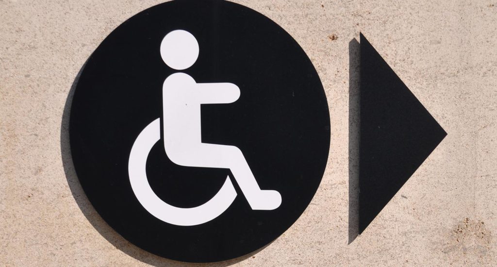 black and white handicap sign on a concrete wall