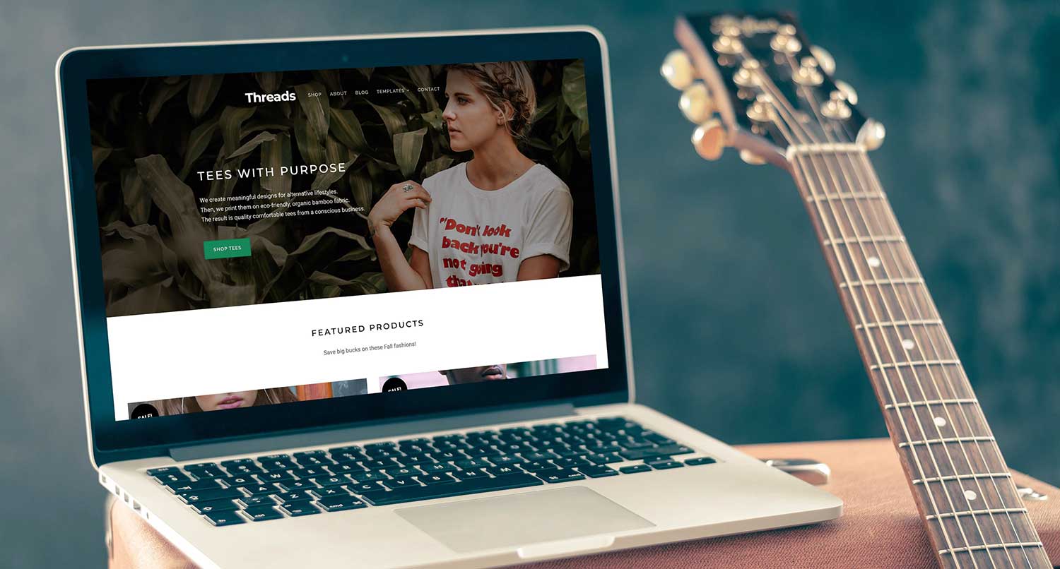 Threads WooCommerce theme homepage on a laptop sitting on a guitar amp