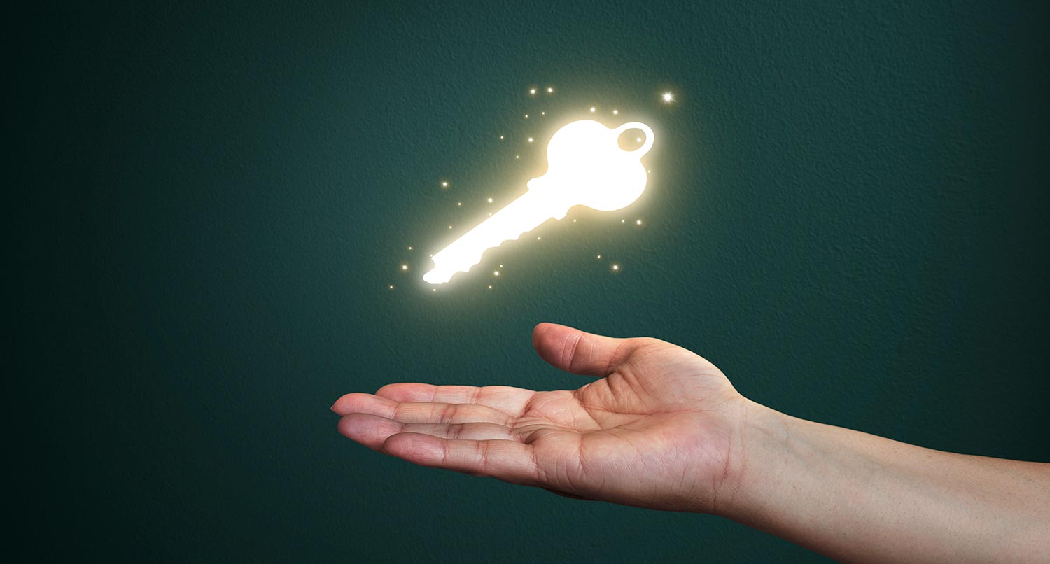 glowing gold key hovering over a hand