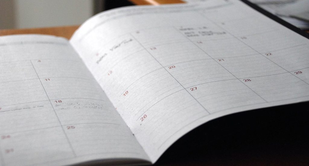Monthly calendar notebook opened on a wooden table