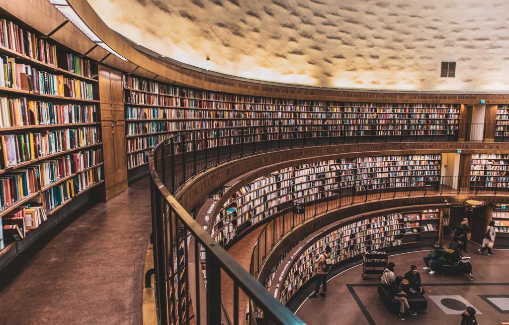 a circular library with three floors of shelves filled with books