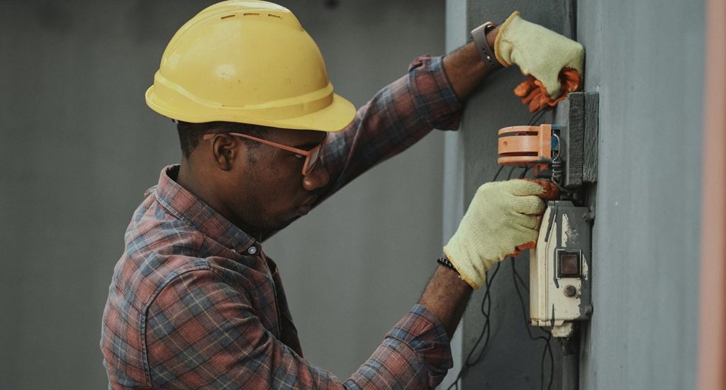 An electrical worker fixing a device on a wall