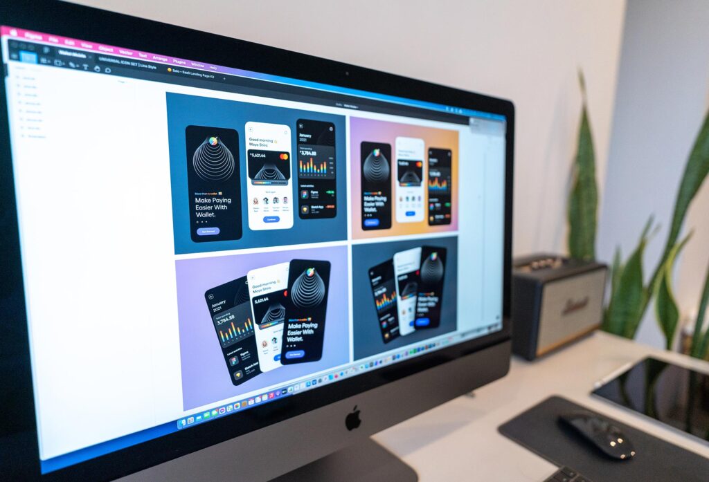 An iMac showing a Figma file with designs for app screens