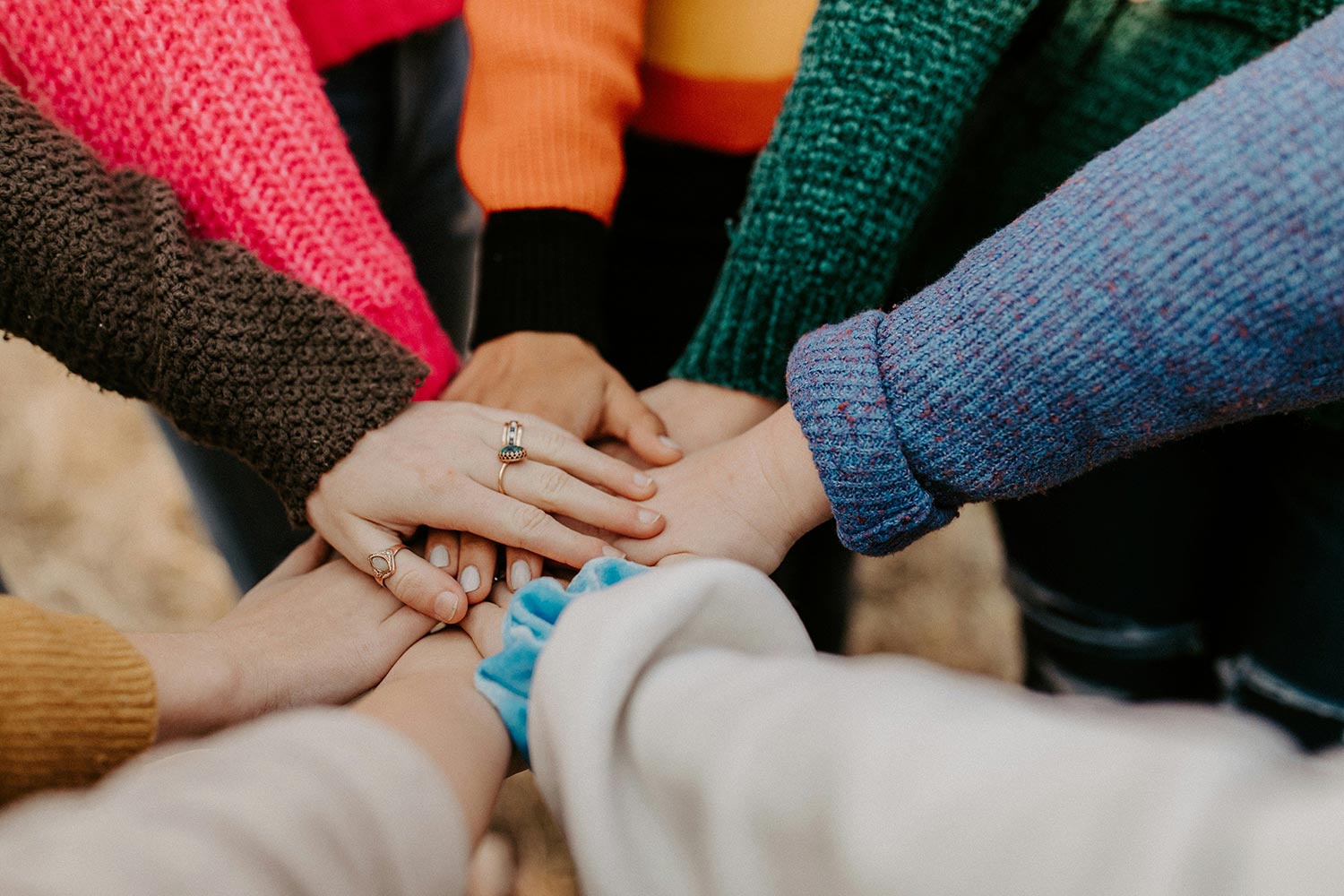 a group of people with their hands in the middle of a huddle