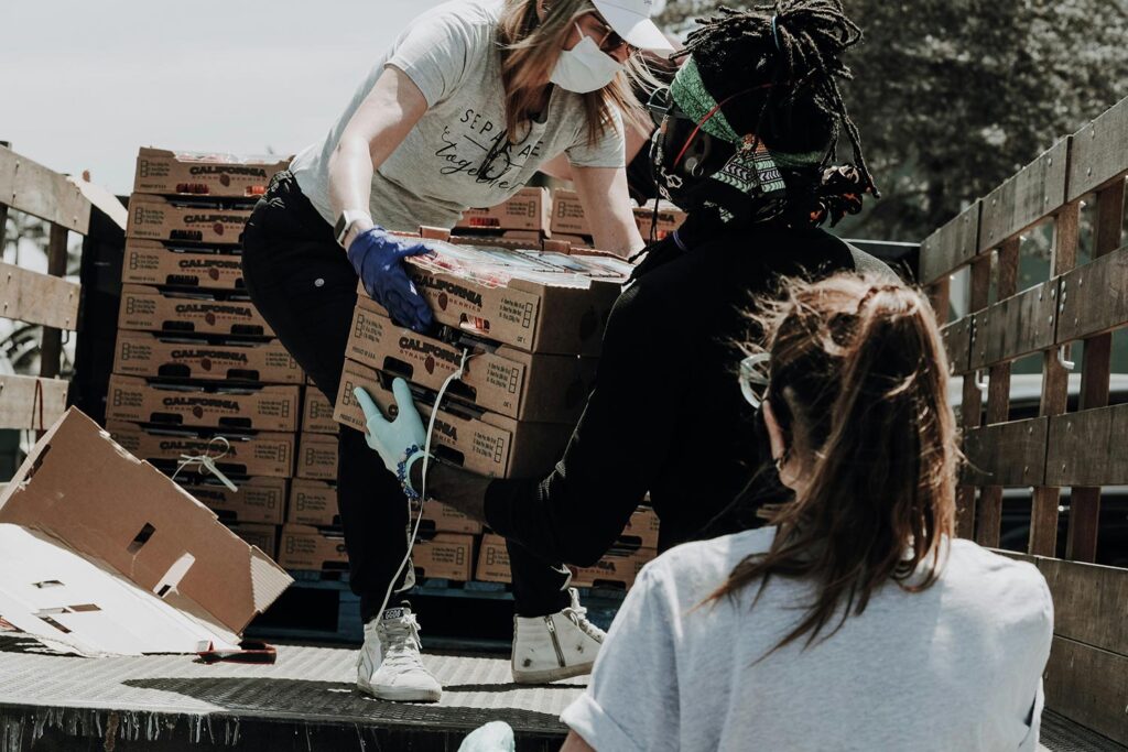 People unloading boxes of donated food off of an open top truck