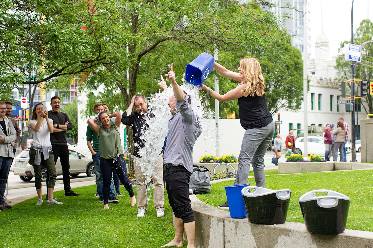 a man partaking in the ice bucket challenge as other people looking on