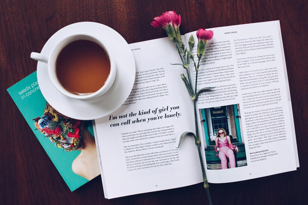 an open magazine with a flower and a cup of tea